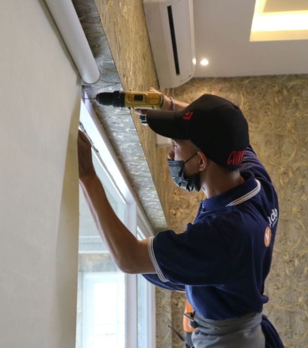 a man is drilling holes in the wall to place curtain rods