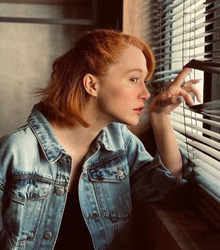 a girl is showing How to Pull Down Blinds Without Strings