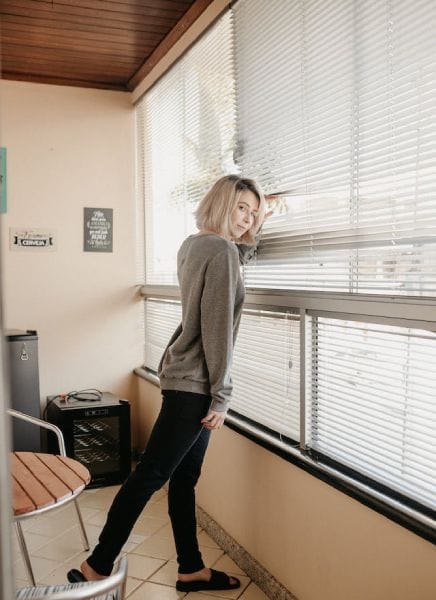 a girl is showing how to close blinds with 2 strings