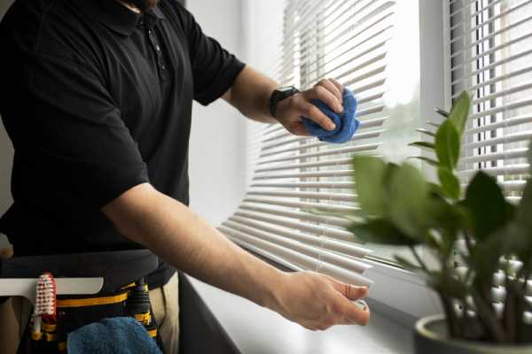 a man is showing How to fix Levolor Blinds by cleaning and taking them down