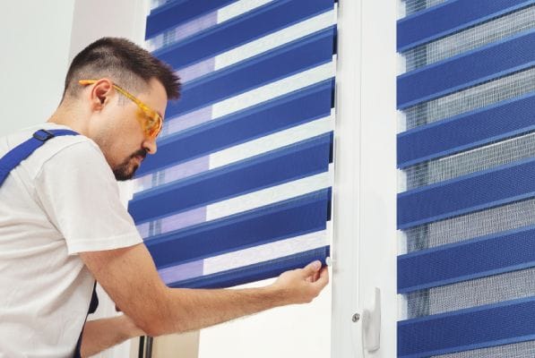 a man is showing how to take down Levolor blinds