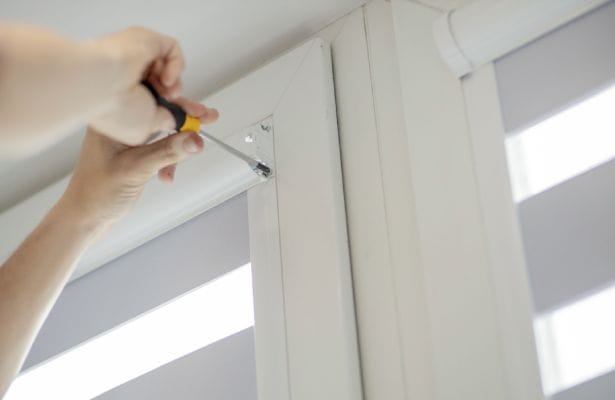 The person is trying to fix the built-in blinds.