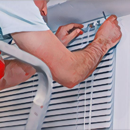 A man is demonstrating how to restring mini blinds.