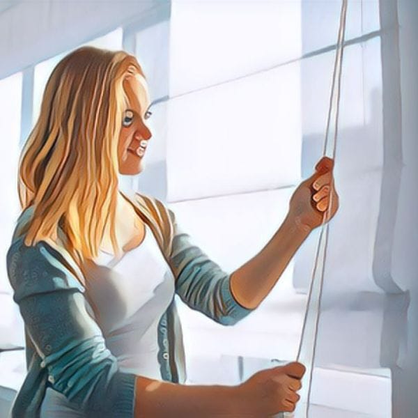 A woman is demonstrating how to restring mini blinds.